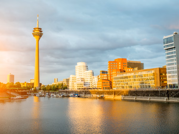 Düsseldorfer Rheinufer mit Rheinturm und modernen Gebäuden im Abendlicht