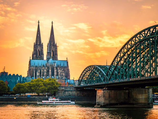 Kölner Dom und Hohenzollernbrücke über dem Rhein bei Sonnenuntergang